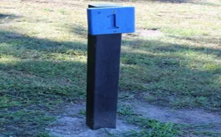a recycled plastic post shown buried in the ground with a sign mounted at the top