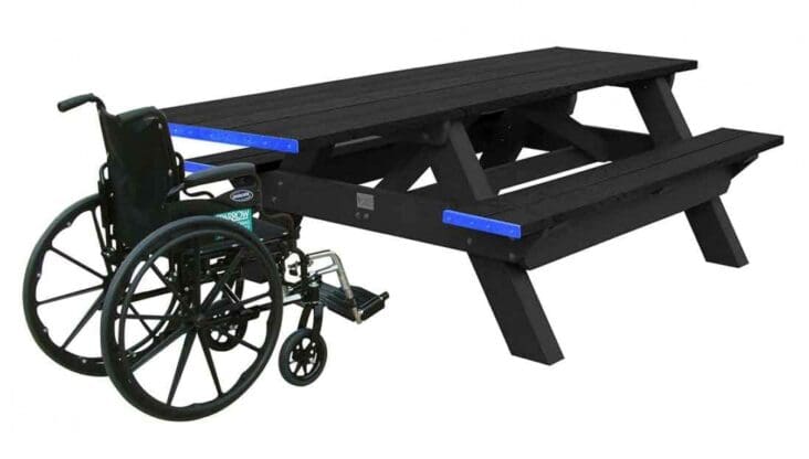 A Deluxe ADA outdoor commercial picnic table with wheelchair access on one end. Made of recycled HDPE plastic. Shown with a black frame and black top and seat boards.