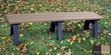 The Economizer Traditional 6 ft flat bench is made from 100% recycled HDPE plastic. This bench has the same design as our Traditional flat bench but uses our lighter weight 1 1/4"x5" planks instead of the standard 2"x6" planks. The bench is shown on grass with a black frame and weathered seat boards.