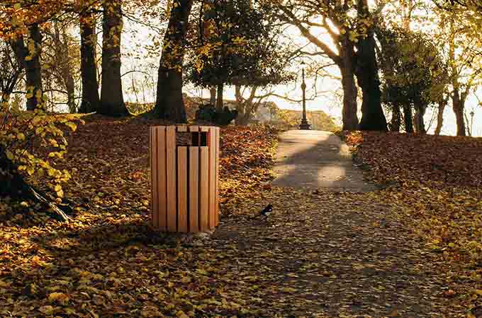 Round 33 Gallon Receptacle with Rain Cap in a park setting