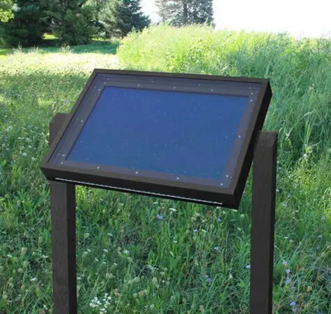 A specialty viewing message center in color black installed on a grassy overlook