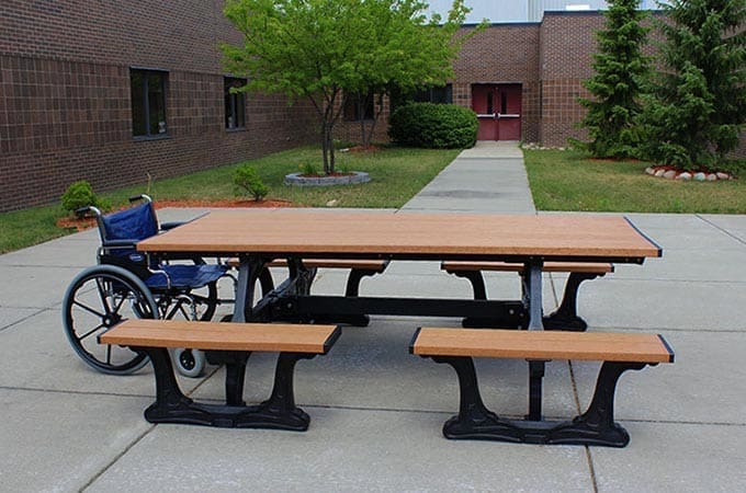 Commons Table ADA compliant table has wheelchair spaces at both ends. The frame looks like decorative cast iron but is made of solid recycled plastic. It's part of the Polly Products collection of ADA compliant picnic tables